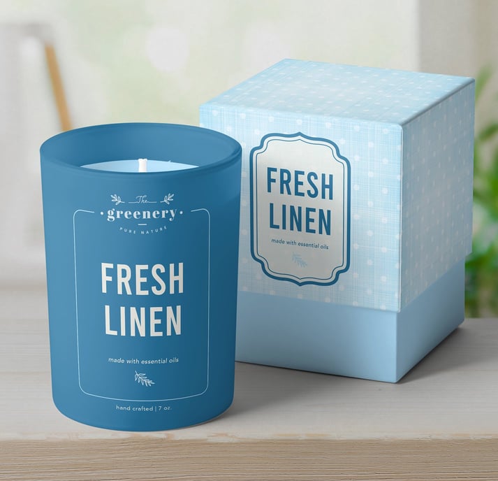 Branded open candle jar next to cardboard packaging box